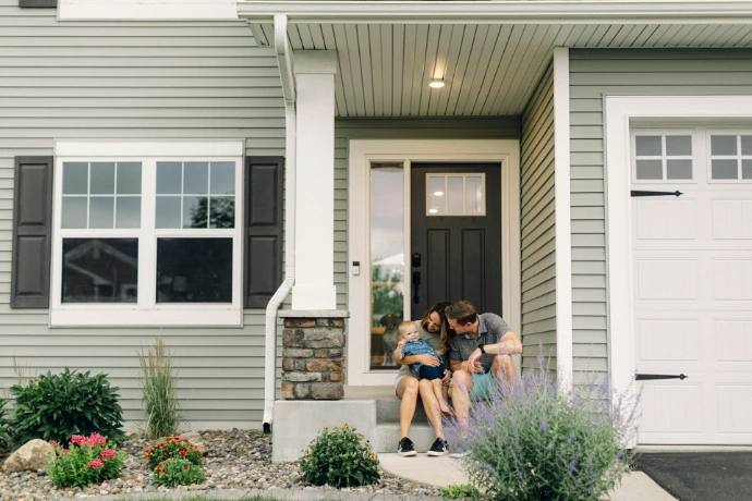 a couple of people that are sitting in front of a house